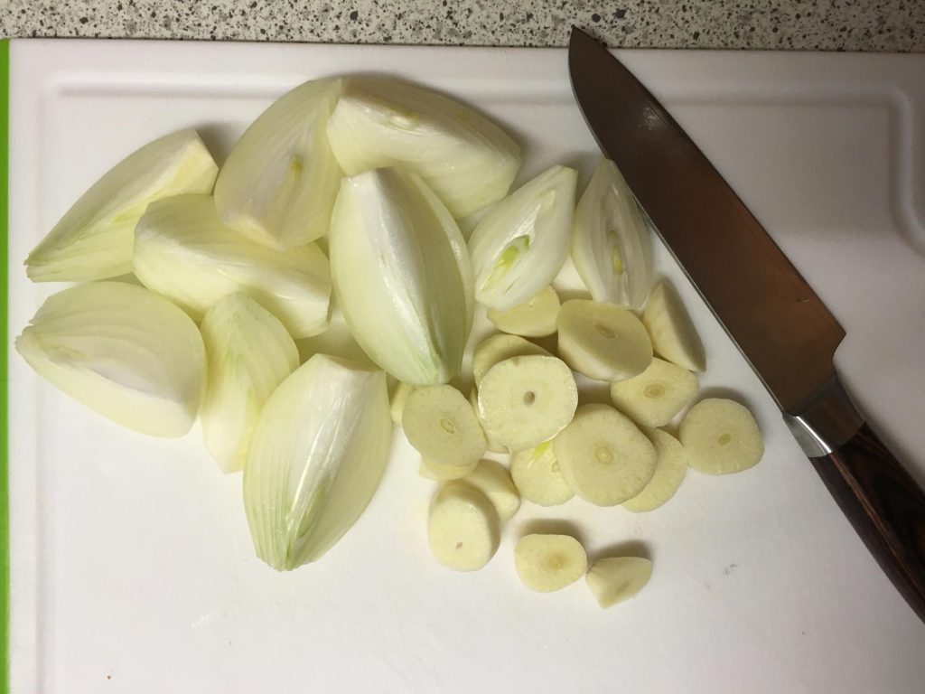 Zwiebeln und Knoblauch vierteln
